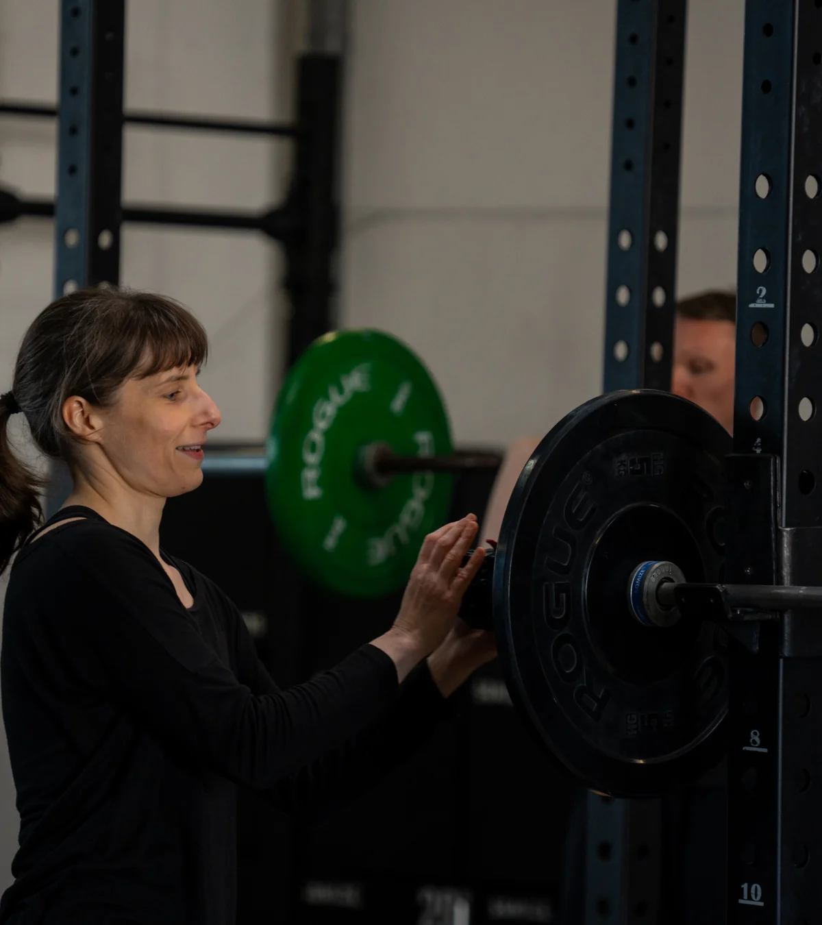 Athletin bereitet eine Langhantel für das Training vor