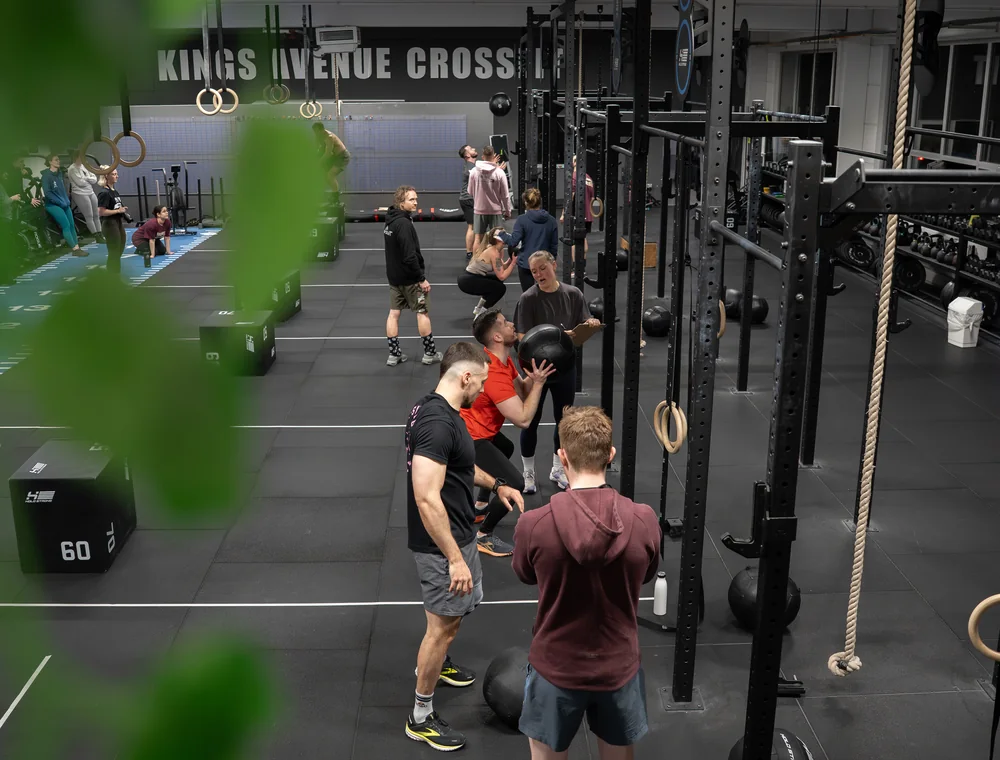 Gemeinsames CrossFit-Training mit Medizinbällen und Übungen am Rig