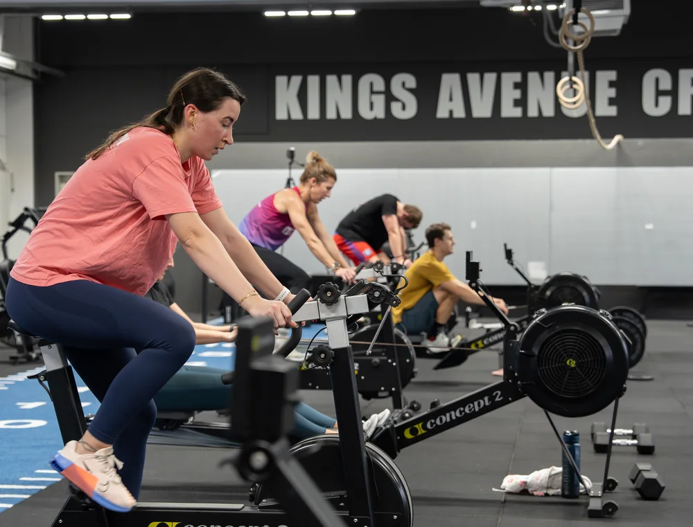 Trainingsgruppe auf Indoor-Bikes und Rudergeräten beim Ausdauertraining